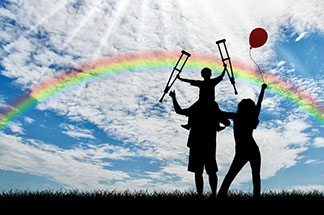 a family playing outside with a rainbow in the sky