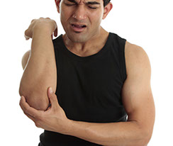 a man in pain and holding his right elbow